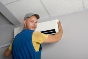 Young setup man installs the new air conditioner in office